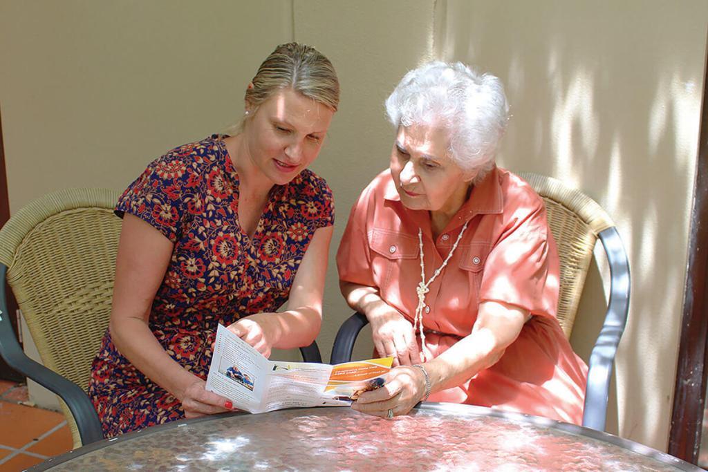 Robyn and Judy reading a brochure at a table, The Co-operative Life