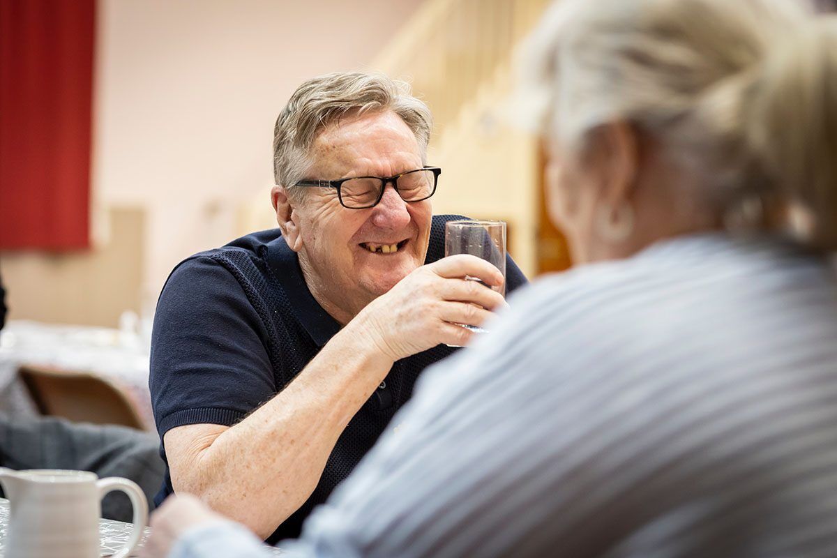 Man with a glass of water laughing