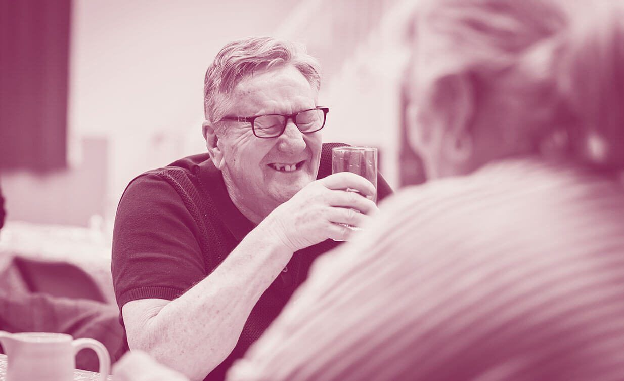 Man with a glass of water laughing