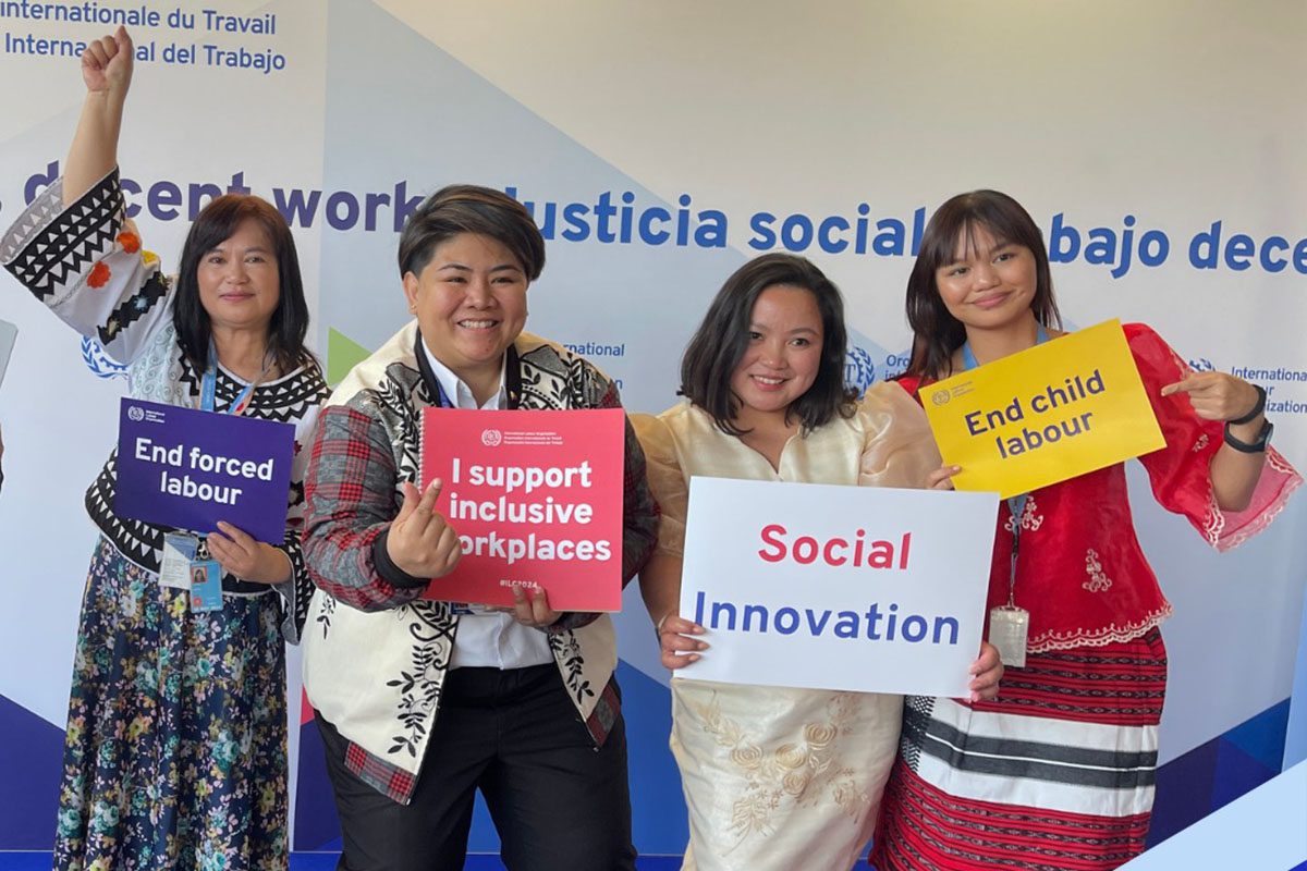 Delegates posed for photos with signs, signalling their support for improving working environments for all. Photo ILO